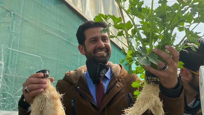 A member of Royal Scientific Society staff with crops produced during the research