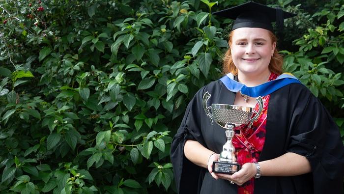 Kate Oakes celebrates with her award at graduation