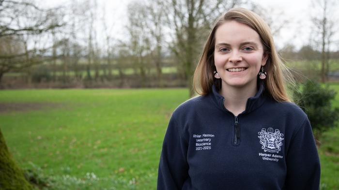 Student Rhian Masson in front of trees with bare winter branches