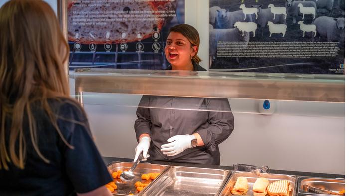 A member of the catering staff prepares to serve a customer